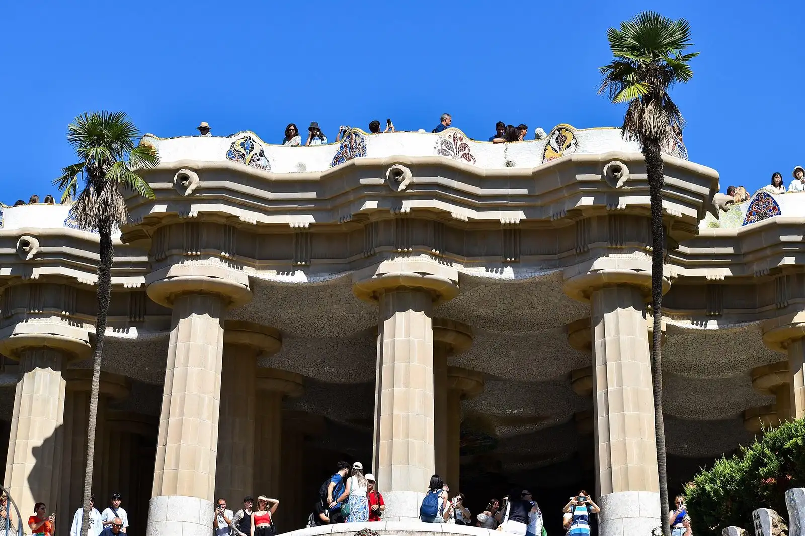 Terraza de la sala hipóstila del Park Güell con columnas y visitantes