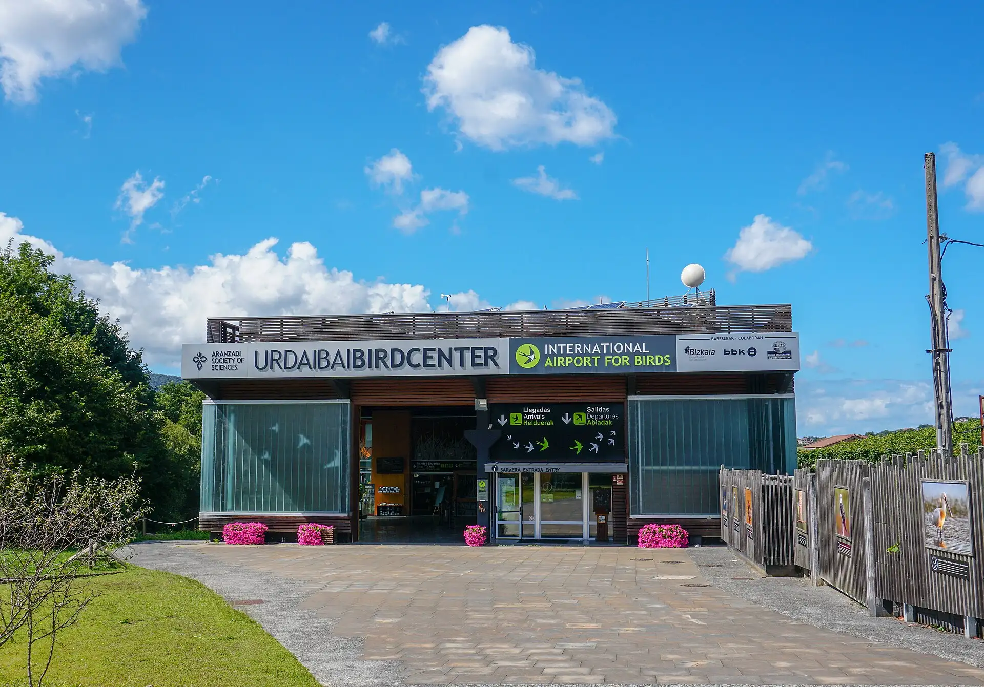 Entrada del edificio del Urdaibai Bird Center con su rótulo y la explanada de acceso